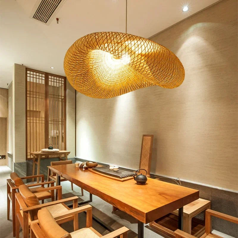 Lampe suspendue en bambou tressé fait main, allumée dans un intérieur