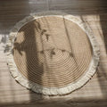 Tapis rond tressé à franges aspect jute dans un salon